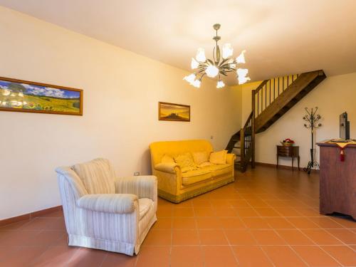 a living room with a yellow couch and two chairs at Holiday Home Lavanda by Interhome in Badia Agnano