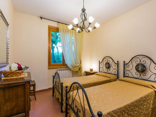 a bedroom with two beds and a table and a window at Holiday Home Lavanda by Interhome in Badia Agnano
