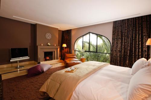 a bedroom with a large white bed and a fireplace at Palais Namaskar in Marrakech
