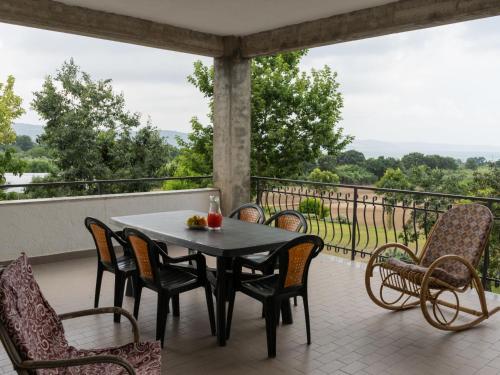 een tafel en stoelen op een balkon met uitzicht bij Holiday Home Rosalba Bacara by Interhome in Bolsena