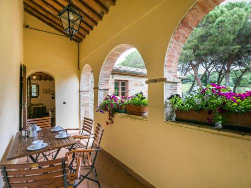 un patio al aire libre con mesa, sillas y flores en Apartment Cellole - Torretta - CTC153 by Interhome, en Castellina in Chianti