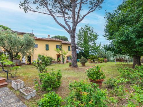 um grande quintal com uma casa amarela e árvores em Holiday Home San Lazzaro by Interhome em Montevettolini