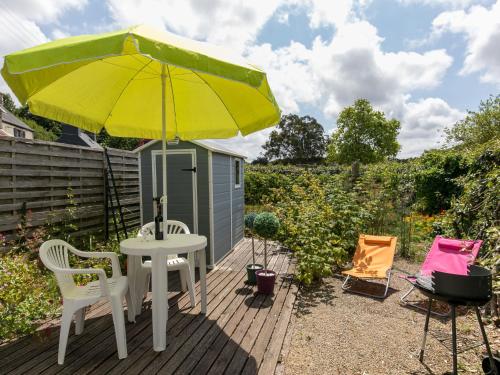 stół z żółtym parasolem na drewnianym tarasie w obiekcie Holiday Home La Littorine by Interhome w mieście Kersiroux