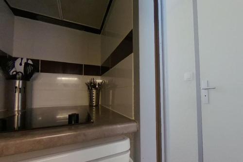 um balcão de cozinha com um lavatório e um espelho em Appartement avec vue mer em Arzon