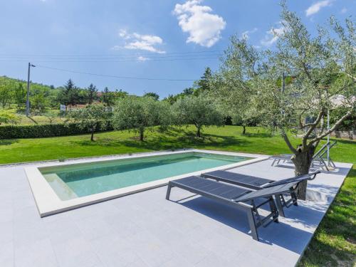 a swimming pool with a bench next to a tree at Holiday Home Carlo - IPC102 by Interhome in Pićan