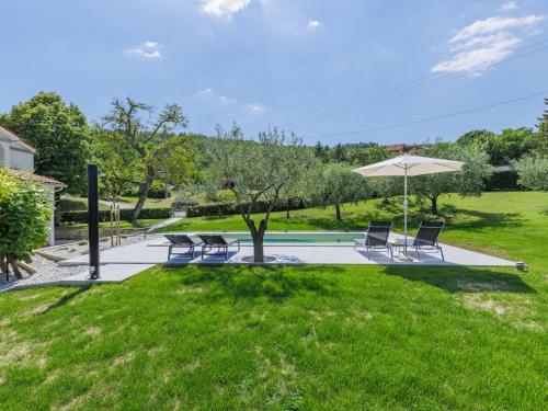 a group of chairs and an umbrella in a yard at Holiday Home Carlo - IPC102 by Interhome in Pićan