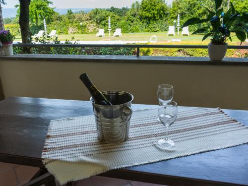 una botella de vino en un cubo sobre una mesa con una copa en Holiday Home Dolce Vita-4 by Interhome, en Bolsena