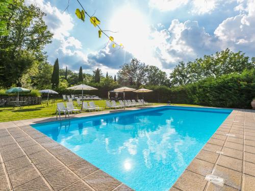a swimming pool with chairs and umbrellas at Holiday Home Ginestra by Interhome in Badia Agnano