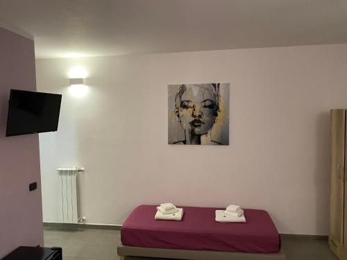 een kamer met een bed en een schilderij van een vrouw bij B&B Italia in Carmiano