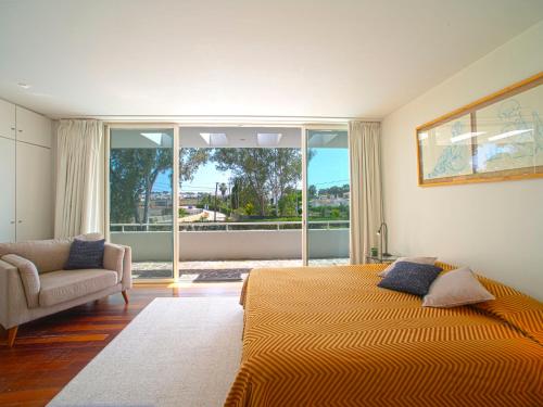 a bedroom with a bed and a couch and a window at Holiday Home Villa Golf by Interhome in Portimão