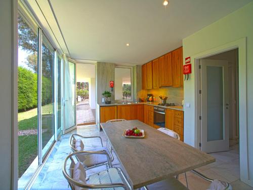 a kitchen with a wooden table and chairs and a table at Holiday Home Villa Golf by Interhome in Portimão
