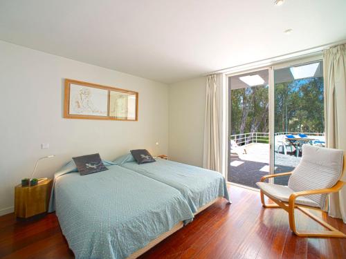 a bedroom with a bed and a chair and a window at Holiday Home Villa Golf by Interhome in Portimão