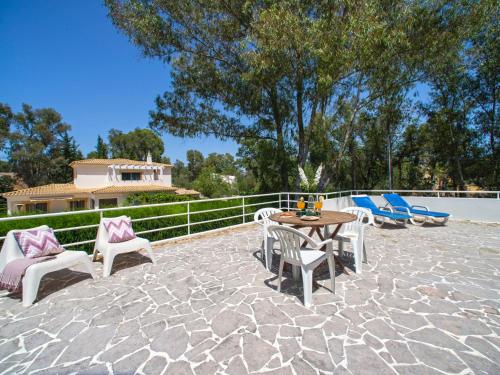a patio with a table and chairs on a stone floor at Holiday Home Villa Golf by Interhome in Portimão