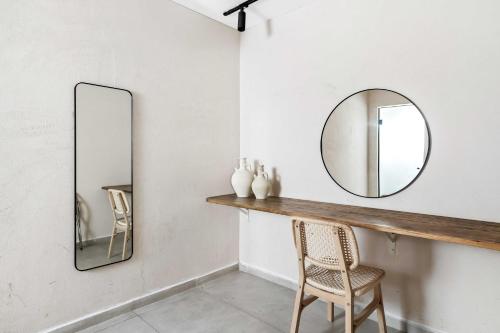 a mirror on a wall next to a table with a chair at Hotel Anilevich Mansion in Beer Sheva