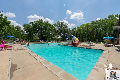 uma piscina num parque com parque infantil em Forest Heights Lodge - 6BR - Pool Table - Near Silver Dollar City - FREE TICKETS INCLUDED em Branson