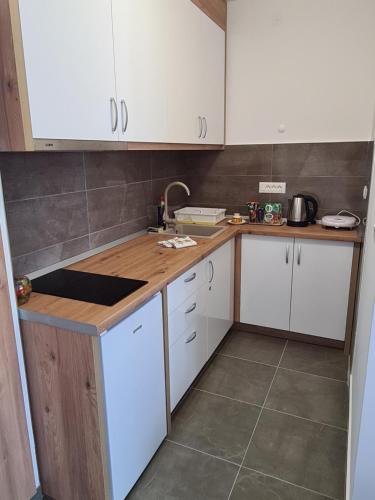 een keuken met witte kasten en een aanrecht bij Apartman Zlatanovic Jagodina in Jagodina