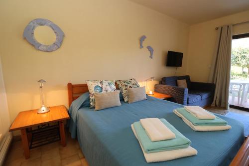 een slaapkamer met een blauw bed met 2 handdoeken erop bij Studio Camélia 67 at São Rafael Beach - Albufeira in Albufeira
