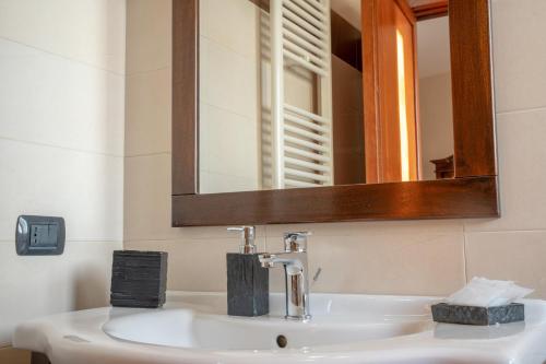La salle de bains est pourvue d'un lavabo blanc et d'un miroir. dans l'établissement B&B Alle Calende Greche, à Martignano