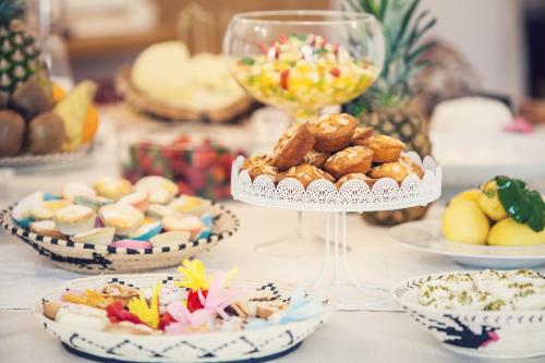 - une table avec des assiettes de nourriture et des bols de desserts dans l'établissement Hotel Il Duomo, à Oristano