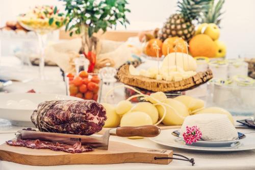オリスターノにあるHotel Il Duomoのチーズ、果物、野菜を盛り付けたテーブル