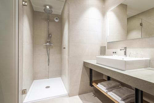 a bathroom with a sink and a shower at Hotel Rosveld in Nederweert