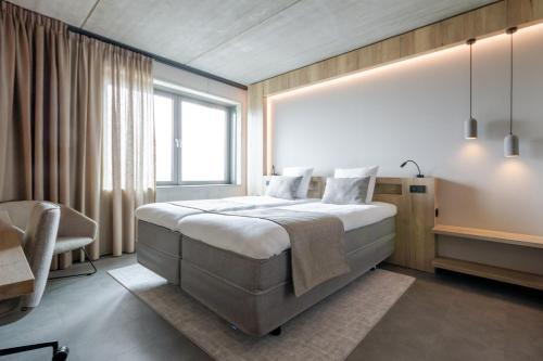 a bedroom with a large bed and a window at Hotel Rosveld in Nederweert