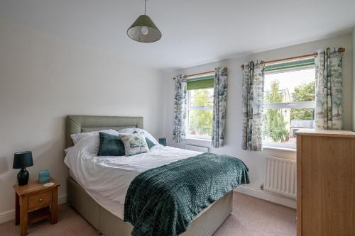 a bedroom with a bed and two windows at 4 Bedroom House in Addingham Ilkley in Addingham