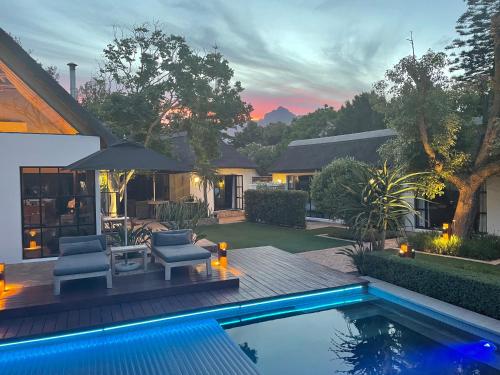 un patio trasero con piscina y una casa en Garden Retreat Guest House, en Ciudad del Cabo