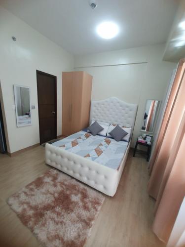 - une chambre avec un lit blanc et un tapis dans l'établissement Manduriao, Iloilo (Lafayette15Z), à Iloilo