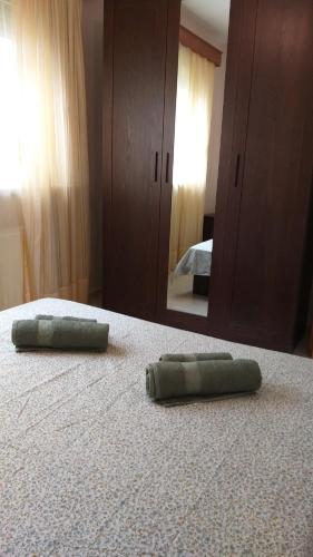 a green pillow on a bed in front of a mirror at Evelins house Alexandroupoli in Alexandroupoli