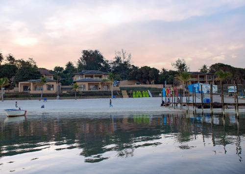 a beach with people and a boat in the water at Bilene Lodge by Dream Resorts in Vila Praia Do Bilene