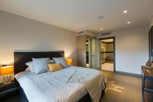 1 dormitorio con 1 cama grande y 2 lámparas en Luxury garden apartment 2BR in the best development of Cap d'Antibes-Juan les Pins en Antibes
