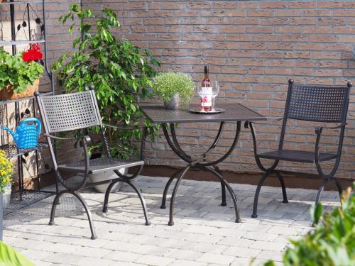 a table with a bottle of wine and two chairs at Ferienwohnung Pension Waldblick in Heidenheim