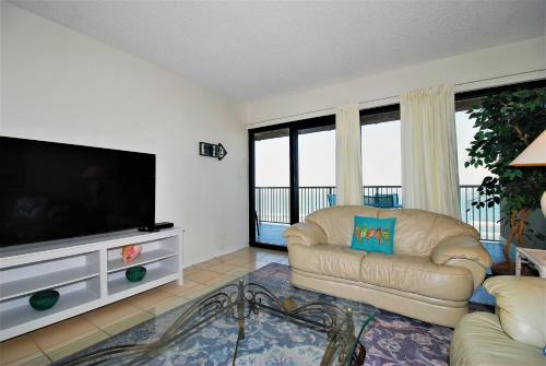 uma sala de estar com um sofá e uma televisão de ecrã plano em Franke Plaza unit #1504 condo em South Padre Island