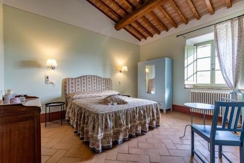 a bedroom with a bed and a chair in a room at Agriturismo I Savelli in Castiglione dʼOrcia