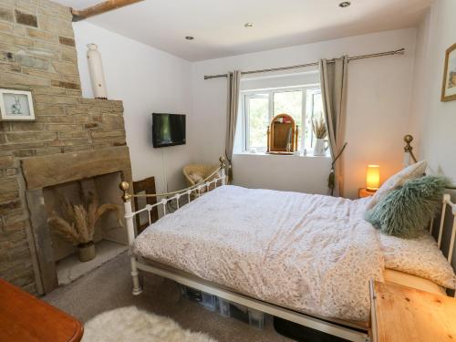 a bedroom with a bed and a fireplace at Ludd Brook Cottage in Halifax