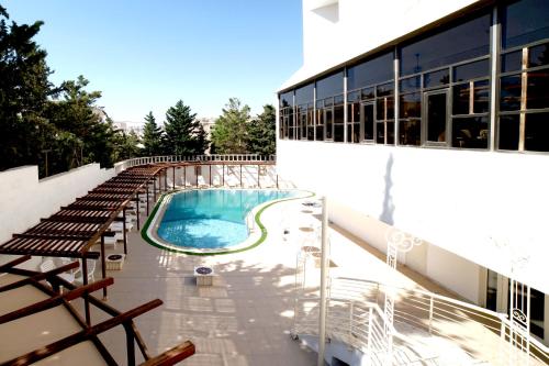 Amman Paradise Hotel في عمّان: مسبح على جانب مبنى
