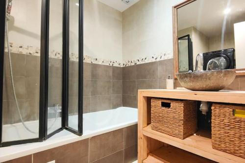bagno con vasca, lavandino e specchio di Appartement Villeneuve Loubet Plage - Spacieux avec Jardin a Villeneuve-Loubet