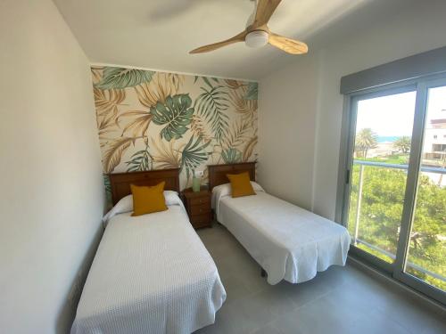 a bedroom with two beds and a ceiling fan at Apto. Burbujas - Marenia´s Dream in Denia