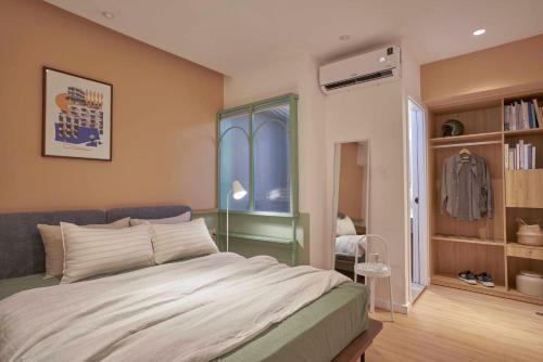 a bedroom with a large bed and a window at M Village Phạm Ngũ Lão in Ho Chi Minh City