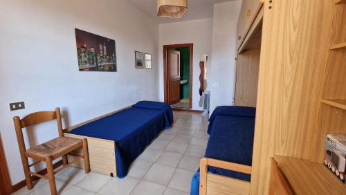 ein kleines Zimmer mit einem Bett und einem Stuhl in der Unterkunft Villa Jolies in Viddalba