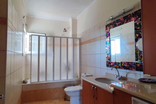 y baño con lavabo, aseo y espejo. en Nefeli home, en Niforeika