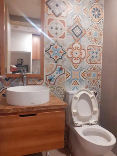 La salle de bains est pourvue de toilettes blanches et d'un lavabo. dans l'établissement Apartemen Skandinavia Tangerang, à Karawaci