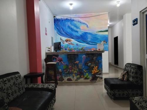 Hostal Playa Imperial Manta في مانتا: غرفة معيشة مع لوحة كبيرة على الحائط