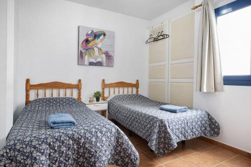 1 dormitorio con 2 camas y ventana en Vista al Mar, La Graciosa en Caleta de Sebo