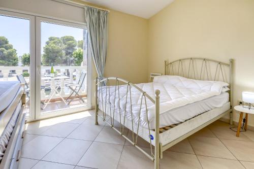 1 dormitorio con 1 cama y balcón en Port Petit 10 Empuriabrava Amarre 3x8 -Immo Barneda, en Empuriabrava