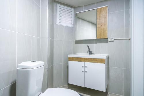 y baño con aseo, lavabo y espejo. en Flat w Balcony 10 min to Uskudar Coast, en Estambul