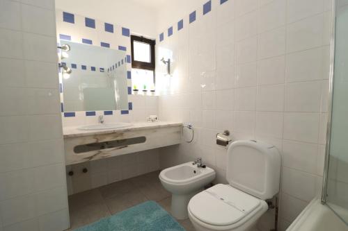 een badkamer met een toilet, een wastafel en een spiegel bij Studio Camélia 67 at São Rafael Beach - Albufeira in Albufeira