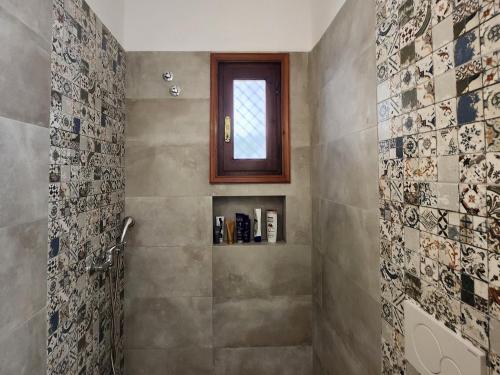 a bathroom with a shower with a window at Theodorou in Azolimnos Syros