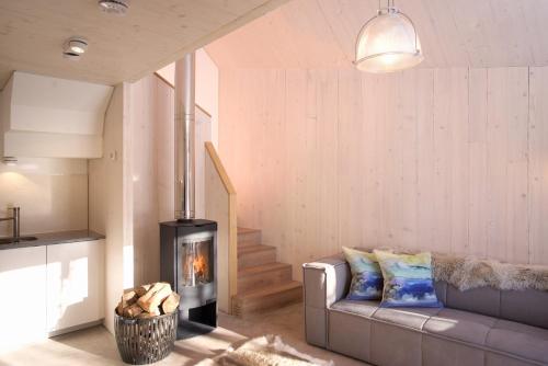 een woonkamer met een bank en een open haard bij Eastside Woodshed - Pentland cabin set in the hills near Edinburgh in Penicuik